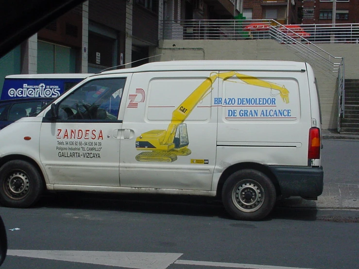 the front of a white van with some adverts on it