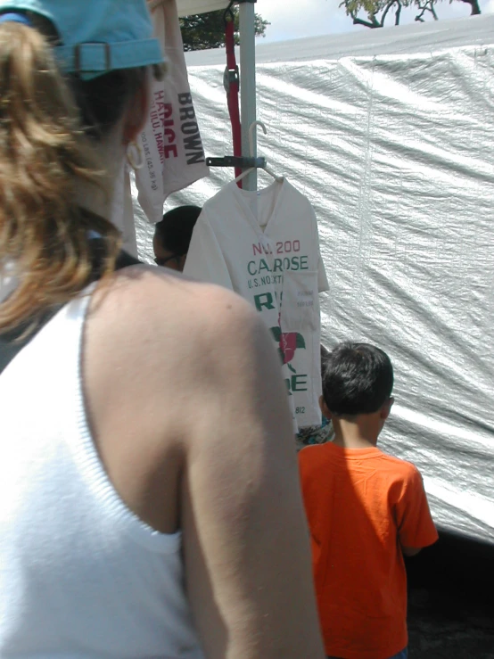 children and their mother standing in front of a tent