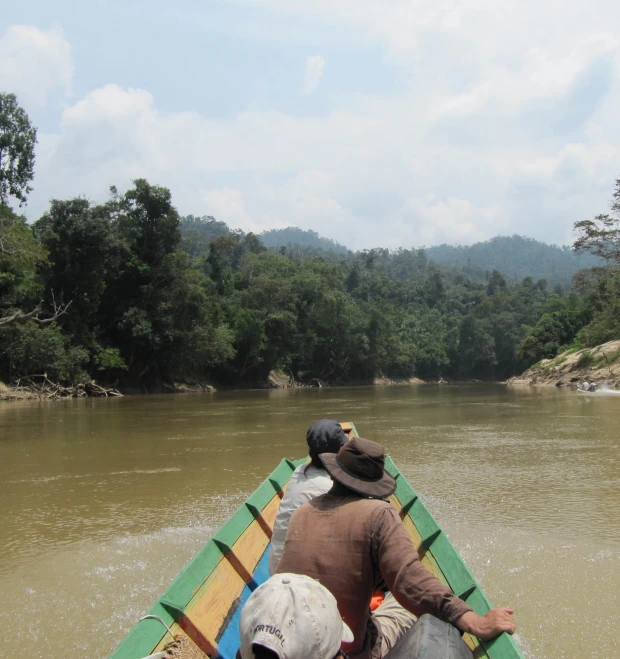 two men paddling in a boat down a river