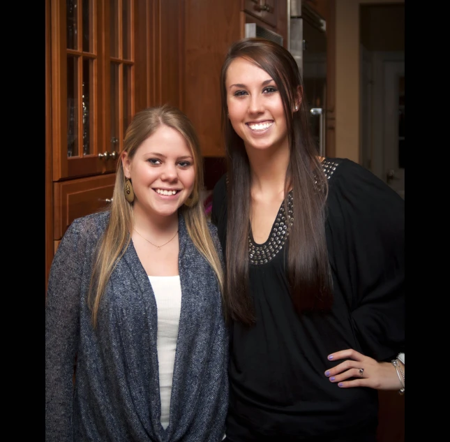 two women standing next to each other smiling