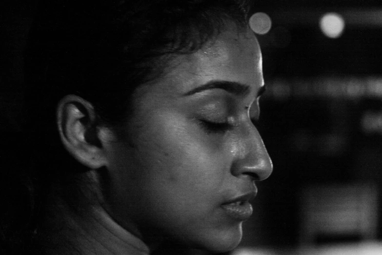 a black and white image of a young woman in profile