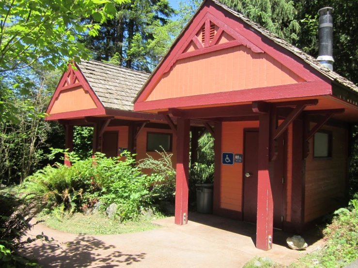 a red and black building with a brown roof