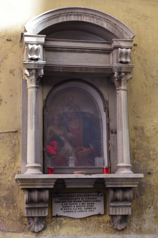 an old building with a window and statues inside