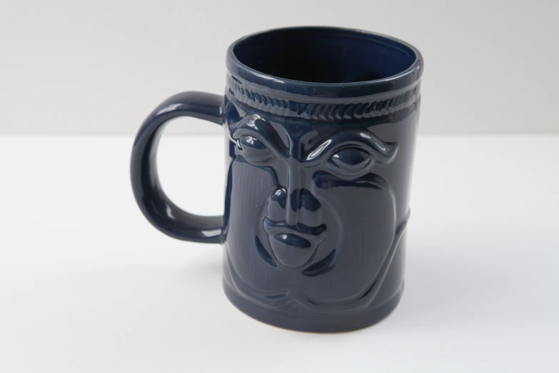 a dark colored mug with a picture of a man in the middle