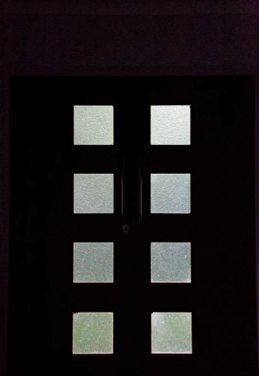 a black door with five square windows and one clock