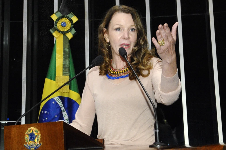 a woman talking to the crowd while speaking into microphone