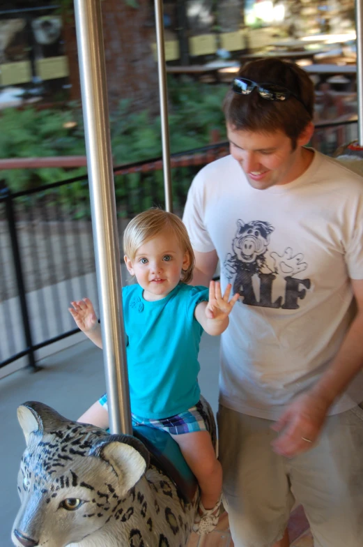 a man with sunglasses on and a  on a carousel