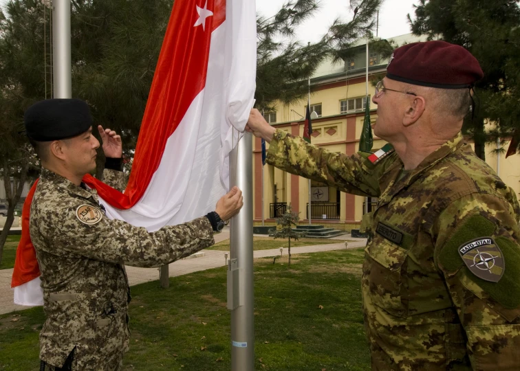 two men in military uniforms with a flag