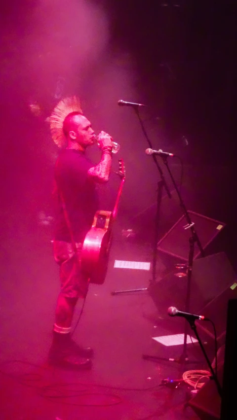 a man standing on stage holding a guitar