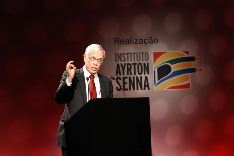 a man in a suit and tie stands at a podium