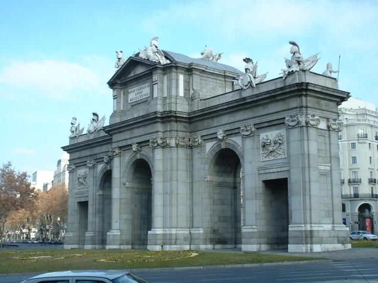 the car is driving by the gray building