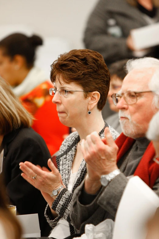 two women and an older man are clapping