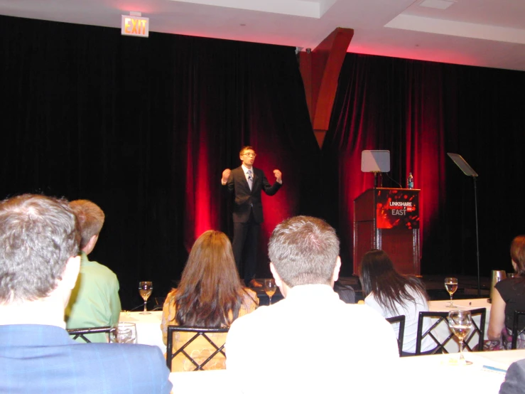 man speaking to a crowd at a conference