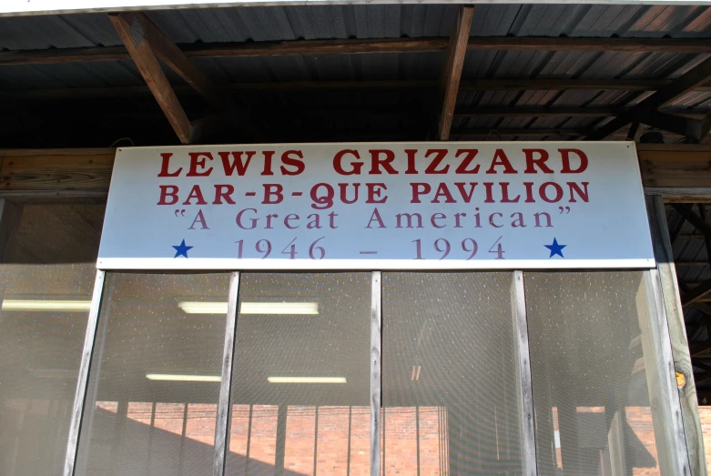 a sign is displayed above a large bar - b - que pavilion