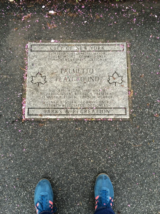 a view of the foot of someone who is standing in front of a plaque