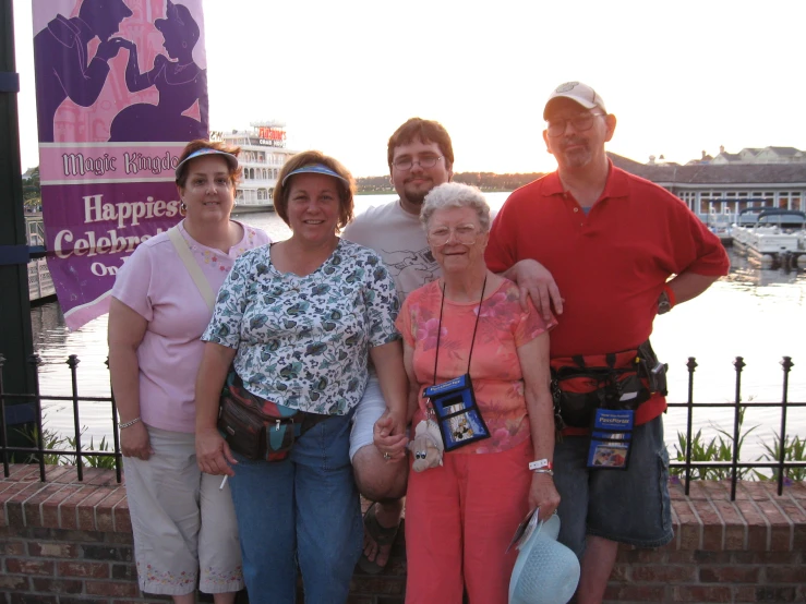 four adults are standing together in front of water