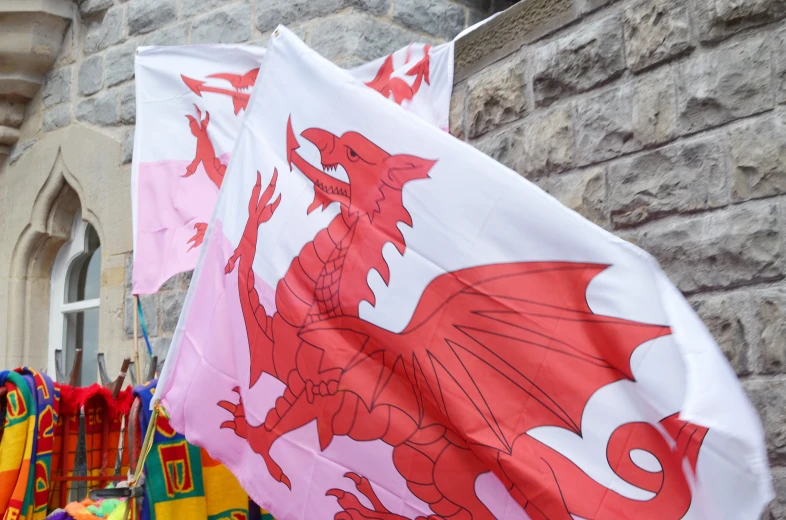 two red and white flags are in front of a building