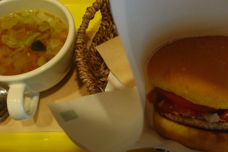 a bowl of soup and hamburgers are served on a tray
