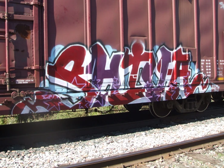 some purple graffiti painted on the side of a train