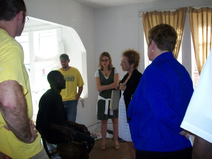 four people standing in the living room are having a discussion