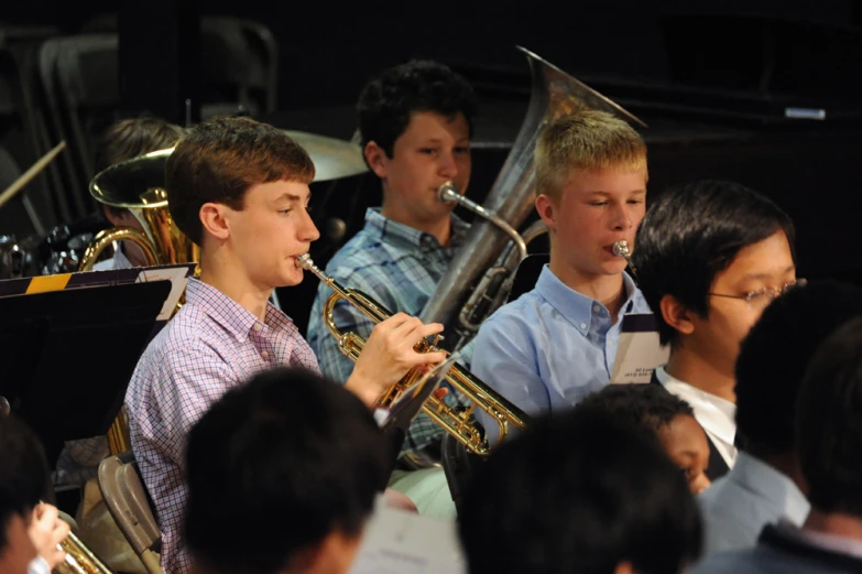 two young musicians performing on their instruments in front of a crowd