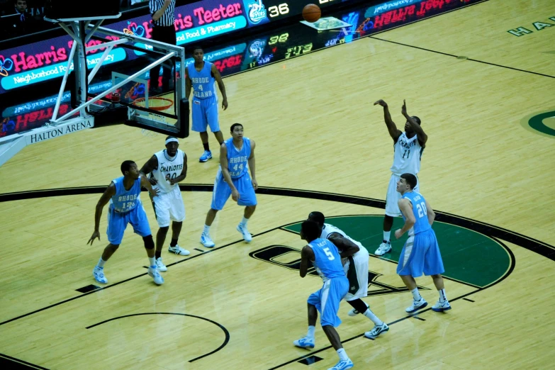 a team of basketball players playing in the middle of a court