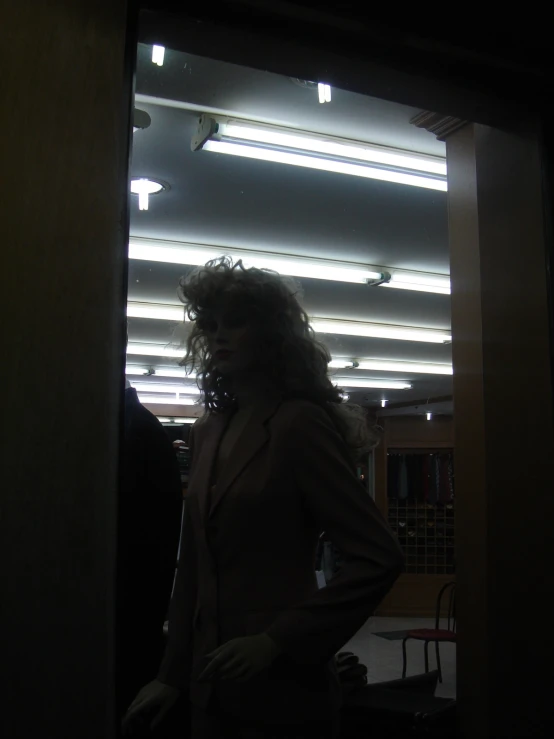 there is a woman standing in the dark, wearing all suit