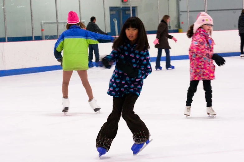 two s ice skating in an indoor rink