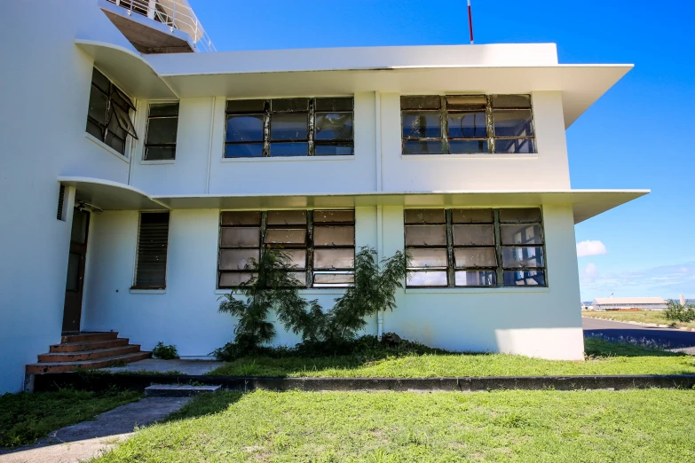 a white building with two floors and windows on the side of it