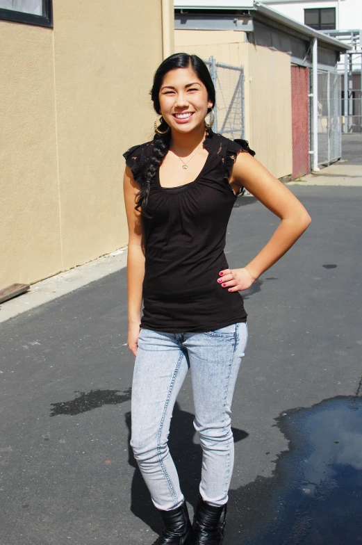 a smiling young woman is standing on the pavement
