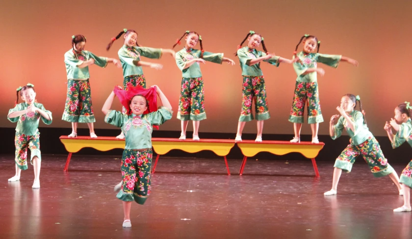 the child performs a variety of exercises while wearing green outfits