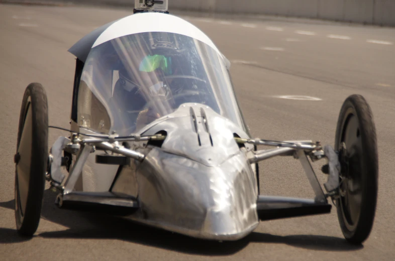 a buggy - like car sits on the ground at speed