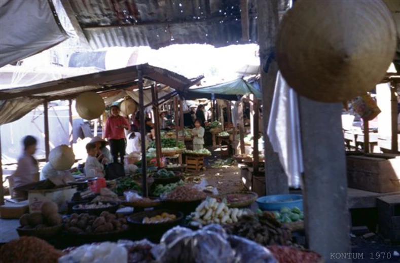 vendors selling produce under a bamboo roof