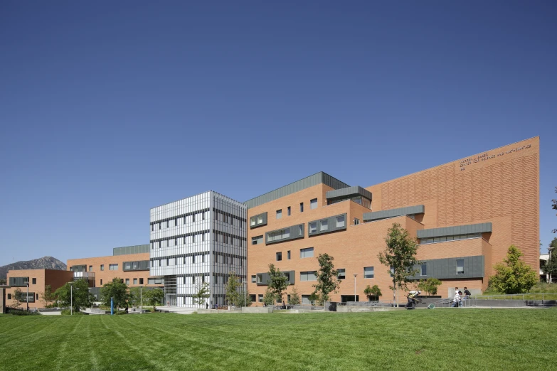 a building made out of red brick sits near a field