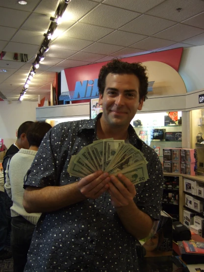 a man holding cash while smiling at the camera