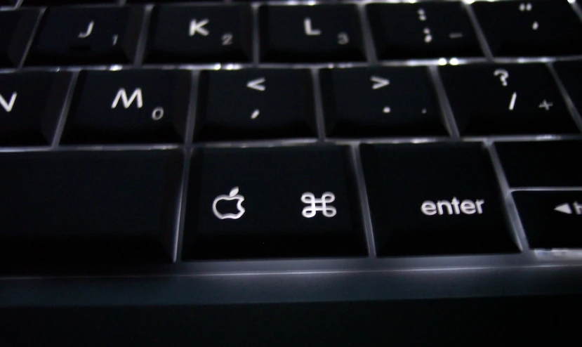 the keyboard of an open laptop with white and black letters