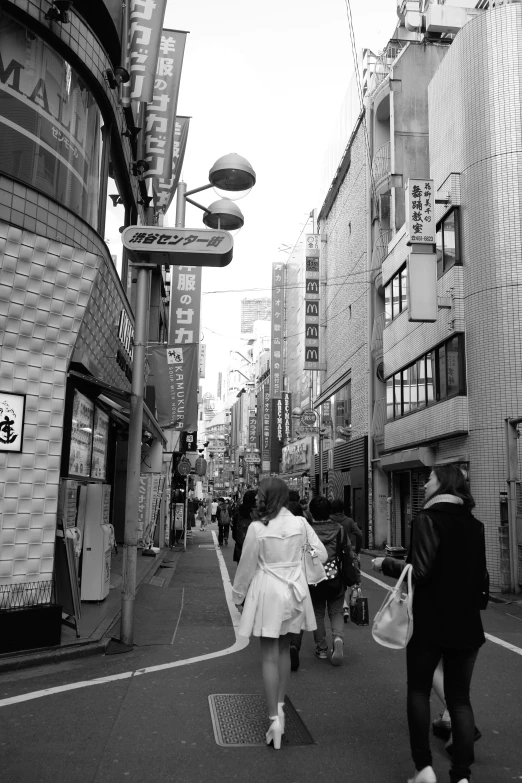 people are walking down the sidewalk on a street