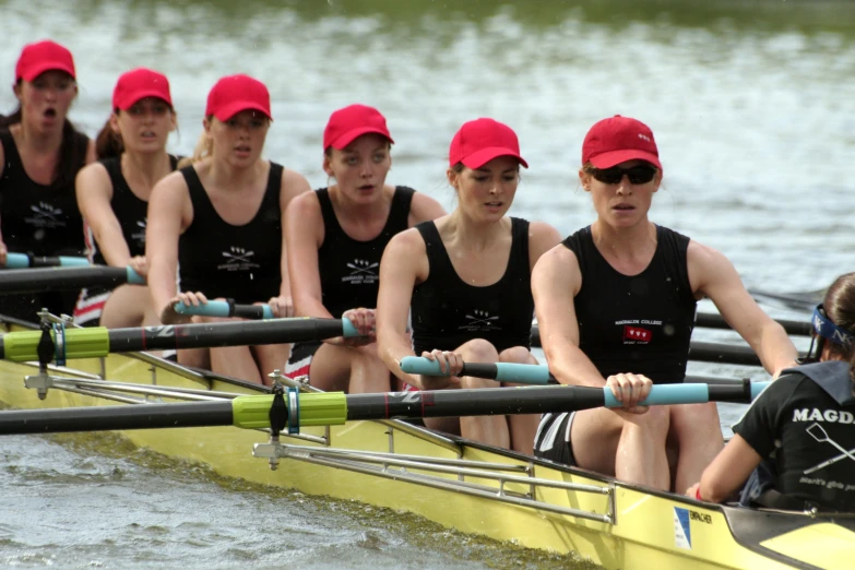 many people sitting on a long yellow boat