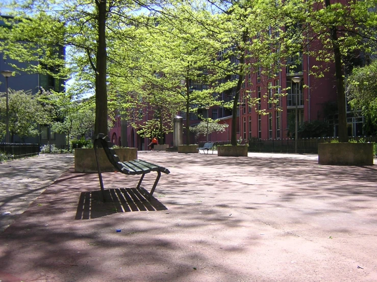 a park bench surrounded by trees in a large courtyard