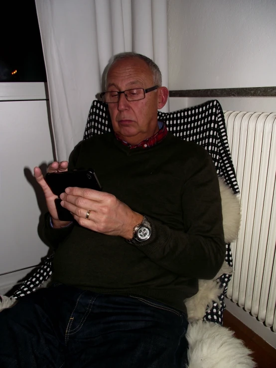 a man sitting in a chair using his phone