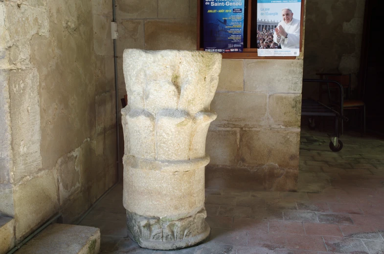 a big stone pillar is on display in an enclosure