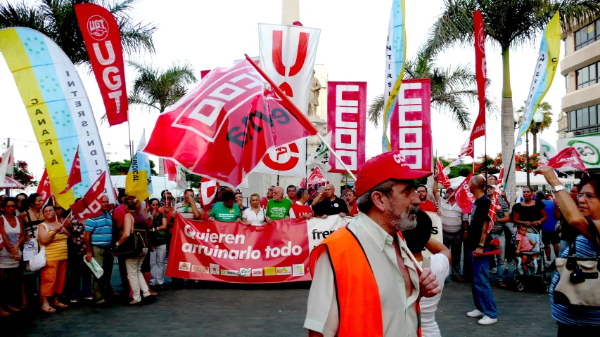 people on a crowded street holding up red and white flags