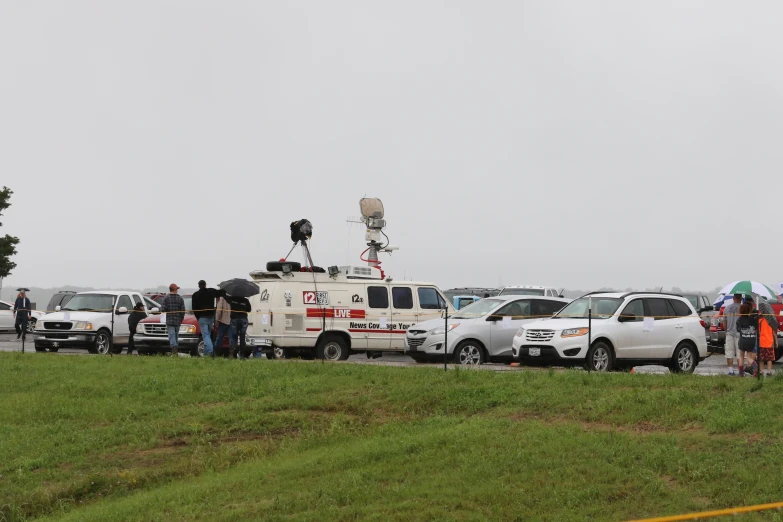 a lot of people standing by some cars