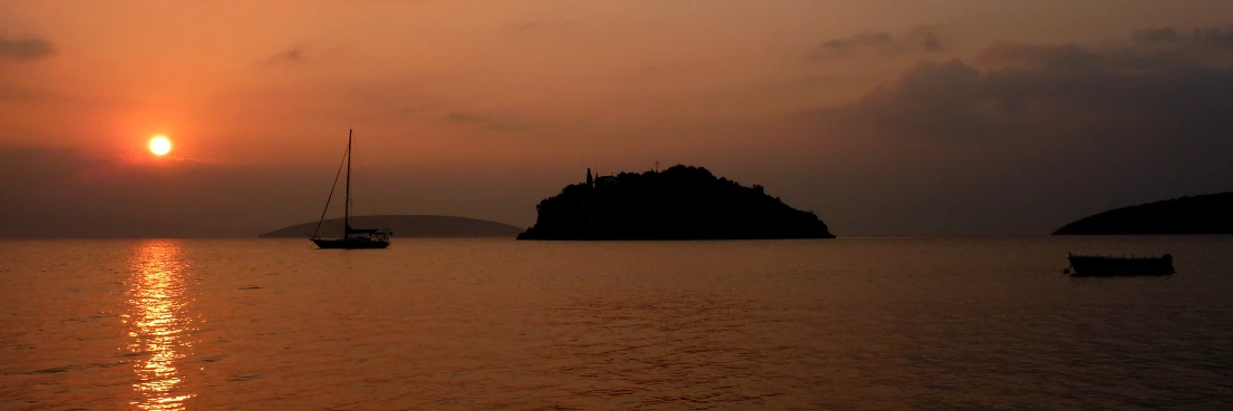 three boats are traveling through the water at sunset