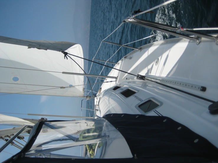 a sailboat on the open ocean with it's sails and some sail