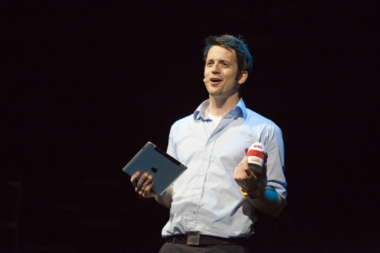 a man holding a clipboard and a drink stands in front of him