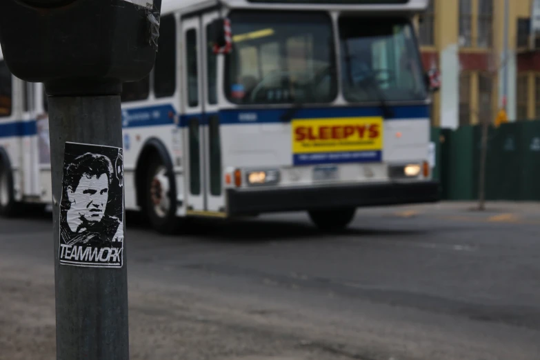 bus with a back - end with sticker on it going down the road