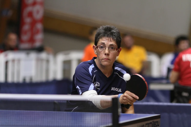 a man holding a ping pong paddle playing doubles