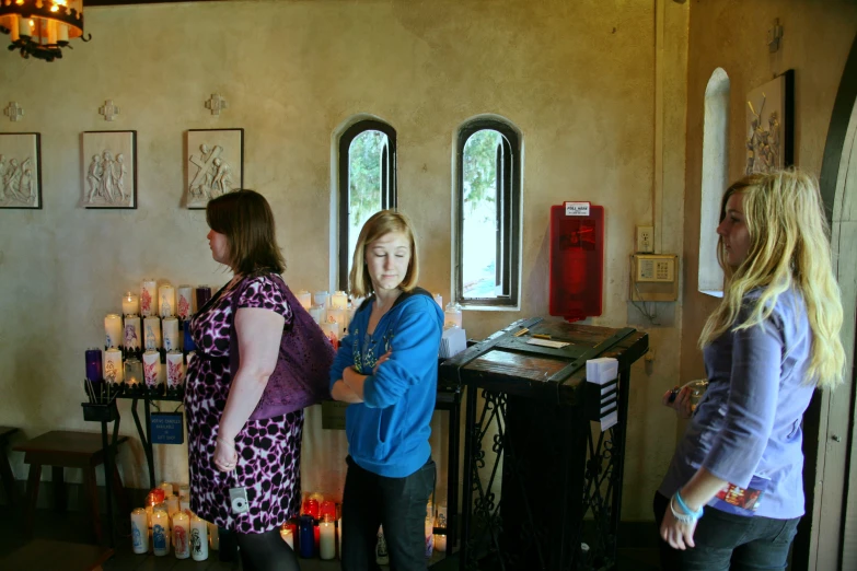 two women standing near a bar and candles