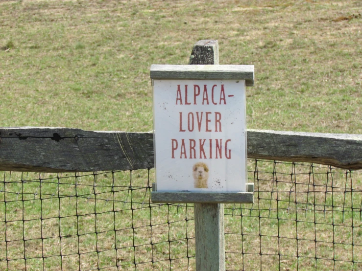 a wooden post next to a fence with a sign